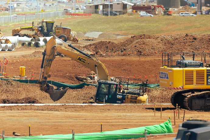 yellow and black excavator on brown field during daytime